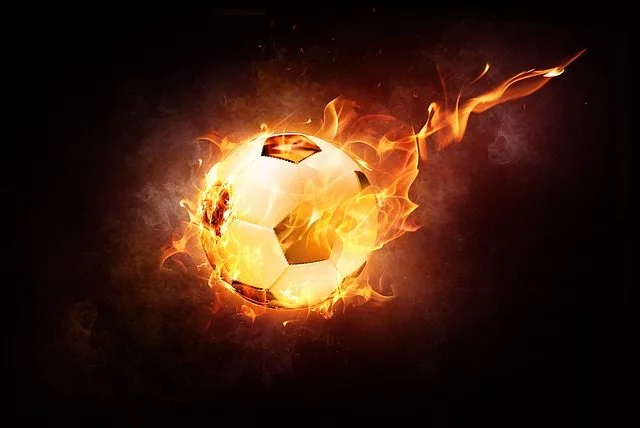 Ballon de football enflammé sur fond noir.